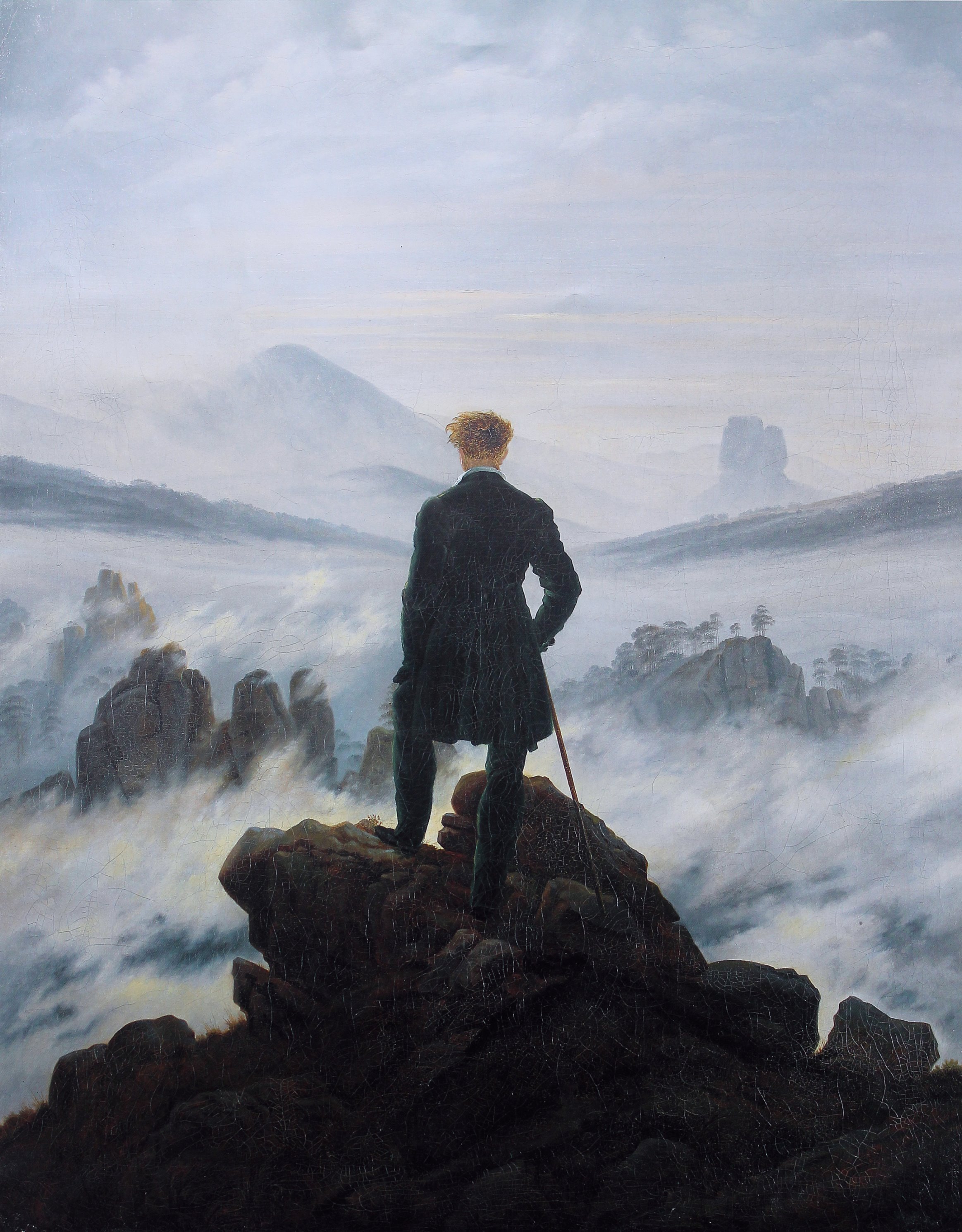 A solitary figure looking across a mist-filled mountain landscape, painted by Caspar David Friedrich